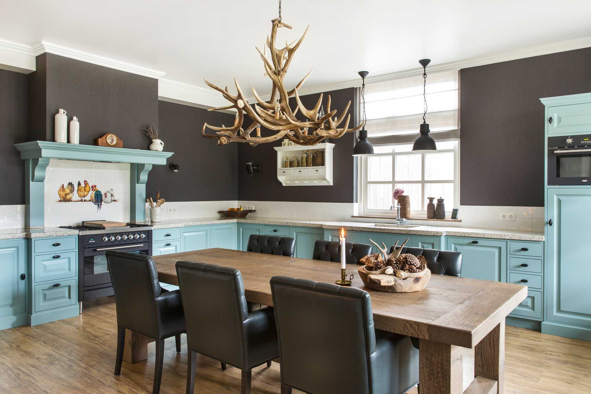 bk blauwe keuken met houten eettafel en hanglampen